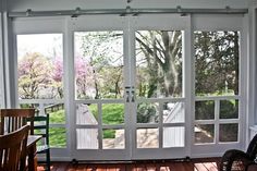 an empty porch with sliding glass doors and rocking chair