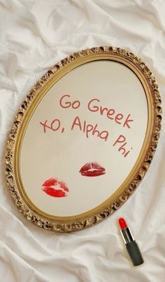 a sign that says go greek to alphabet ph with lipstick on it next to a pen