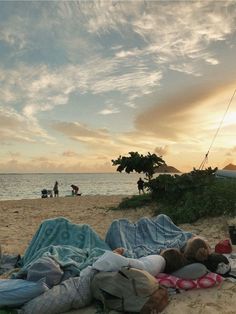 a group of people laying on top of a sandy beach