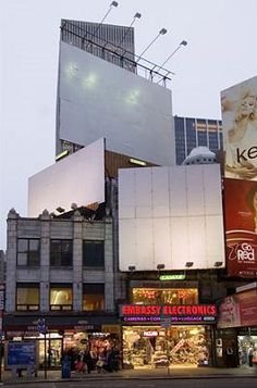 a city street filled with tall buildings and lots of billboards on the side of it