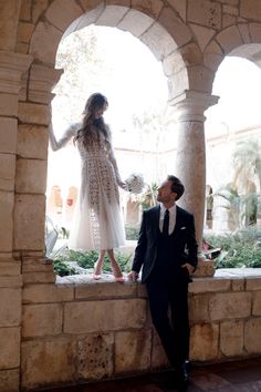 a man standing next to a woman in a white dress