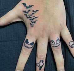 a person's hand with some tattoos on it