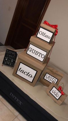 three boxes are stacked on top of each other and tied with red ribbon to give them the name tags