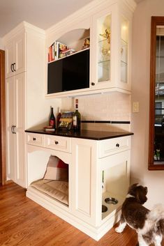 a kitchen with white cabinets and black counter tops in the middle of wood flooring