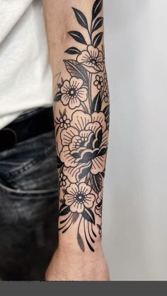 a black and white flower tattoo on the arm