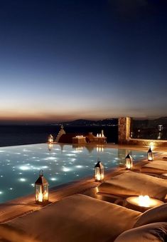 an outdoor pool at night with lit candles