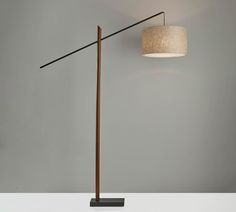 a lamp that is sitting on top of a table next to a light fixture with a fabric shade over it