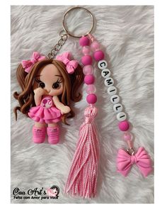 a key chain with a doll and name tag attached to it