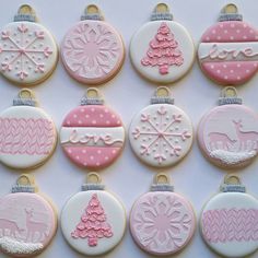 twelve decorated christmas cookies in pastel pink and white