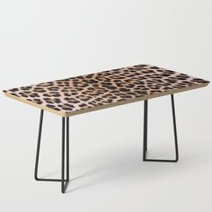 a wooden table with black metal legs and a patterned design on it, against a white background