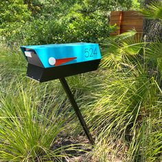 a mailbox sitting in the middle of some tall grass