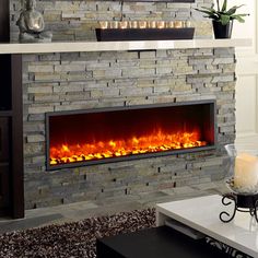 a living room with a fire place in the center and candles on the fireplace mantle