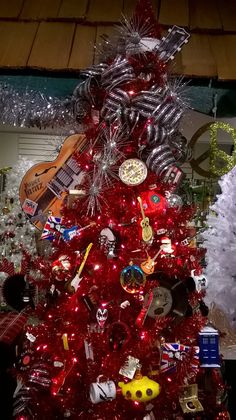 a red christmas tree with lots of decorations