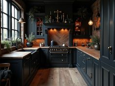 a kitchen with dark blue cabinets and wood flooring is pictured in this image, there are potted plants on the window sill