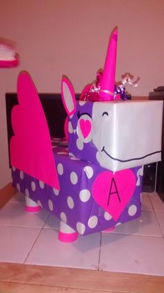 a purple and white box with a pink unicorn on it's side sitting on the floor