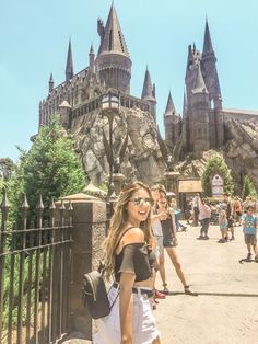 a woman is standing in front of hogwarts castle at universal studios, hollywood