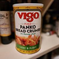 a can of panko breadcrumbs sitting on top of a counter next to a bottle of wine