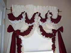 a window with red and white ruffled curtains