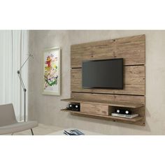 a flat screen tv mounted to the side of a wooden wall with shelves below it