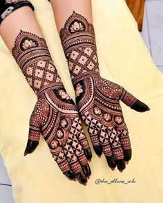 two hands with henna tattoos on them