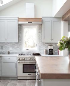 a kitchen with an oven, stove and sink under a skylight in the ceiling