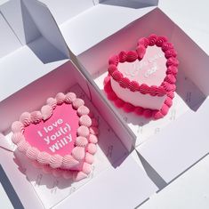 two heart shaped cakes in boxes with the words i love you will written on them