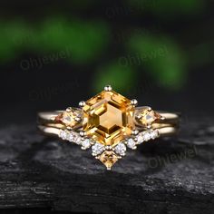 a yellow diamond ring on top of a piece of wood