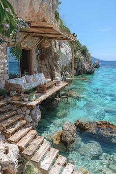 the water is crystal blue and clear with some steps leading up to an outdoor seating area