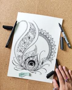 someone is drawing an intricately detailed design on paper with markers and crayons