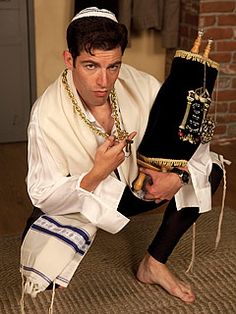 a man dressed in traditional jewish garb holding an object