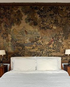 a bedroom with a large tapestry on the wall and two nightstands next to it