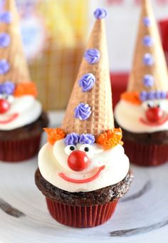 cupcakes with frosting and decorations on them are sitting on a plate in front of other cupcakes