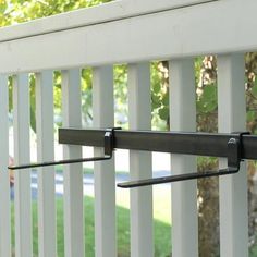 a close up of a metal rail on a white fence