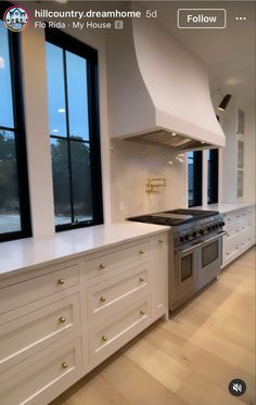 a large kitchen with white cabinets and an island in the middle is featured on instagram