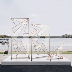 a sculpture on top of a white platform near the water