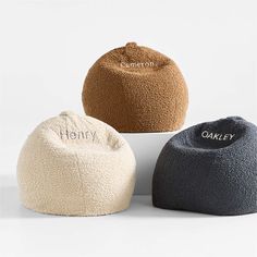 three bean bags sitting next to each other on top of a white surface with the word henry written on them