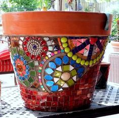 a potted plant sitting on top of a table covered in lots of colorful tiles