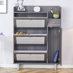 a shelf with baskets on top of it in front of a striped wallpapered wall