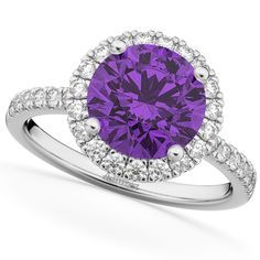 a cushion shaped purple diamond surrounded by white diamonds in a halo setting with two rows of pave set shoulders