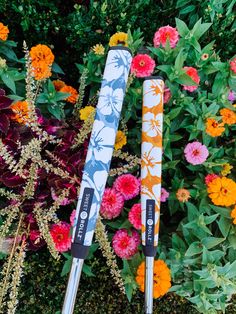 two snow skis laying on top of each other in front of some colorful flowers