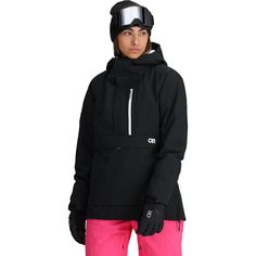 a woman in pink pants and black jacket with ski goggles on her head, looking at the camera