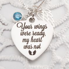 a heart shaped necklace with an angel wing on it