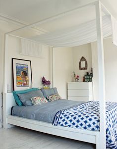 a white bed with blue sheets and pillows