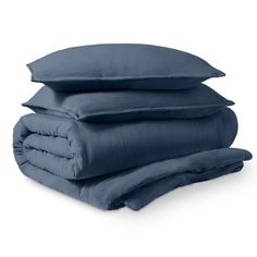 three pillows stacked on top of each other in front of a white background with blue sheets