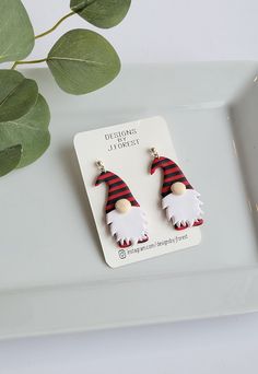 the earrings are decorated with red and white gnomes