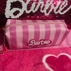 pink and white striped bag with barbie logo on it