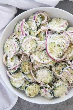 a white bowl filled with cucumber salad on top of a table