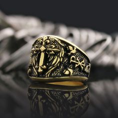 a gold ring with a lion and cross on it