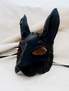 RABBIT MASK IN BLACK LEATHER This item is available to order. Please allow three weeks before shipping. Our masks are made entirely by hand, all in genuine leather and wearable. The masks are designed not only as art objects, but also to be worn. Thanks to our special process the leather retains its elasticity allowing a good fit of the mask. The leather we luse is tanned using vegetable products. The casts of which are shaped masks are in clay and its are designed and produced by us. Thanks a l Pagan Magic, Rabbit Rabbit Rabbit, Rabbit Costume, Bunny Mask, Black Bunny, Mask Shapes, Black Rabbit, Leather Mask, Costume Mask