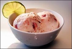 two scoops of ice cream in a bowl with a lime slice on the side